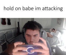 a man wearing headphones takes a picture of a woman laying on a bed with the words hold on babe im attacking below him