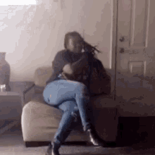 a woman is sitting on a couch in a living room holding a gun .