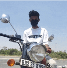 a young man wearing a mask is riding a motorcycle with a license plate that says br3 25 8950