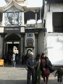 a group of people are standing in front of a building that says ' shree ganesh ' on the front