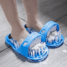 a person wearing a pair of blue slippers with brushes in them