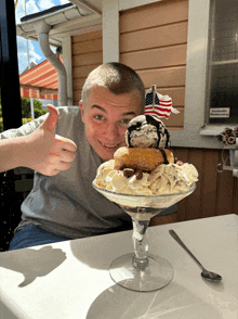 a man giving a thumbs up in front of a huge sundae