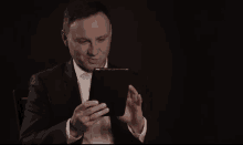 a man in a suit is using a tablet