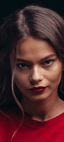 a close up of a woman 's face with red lipstick on