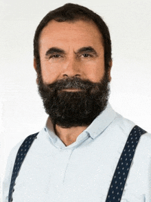 a man with a beard and suspenders is wearing a light blue shirt