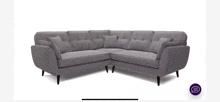 a gray sectional couch with wooden legs and pillows