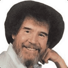 bob ross is a man with a beard and a hat .