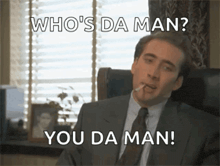 a man in a suit and tie is smoking a cigarette and says who 's da man you da man .