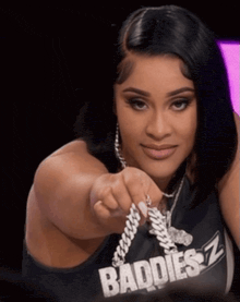 a woman wearing a shirt that says baddies is pointing