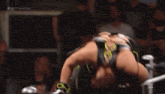 a woman is wrestling in front of a crowd and the words # nxttakeover are on the screen