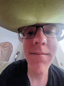 a man wearing glasses and a cowboy hat on his head