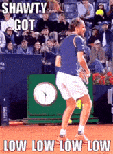 a man in a blue shirt and white shorts is holding a tennis racquet on a tennis court with a crowd watching .