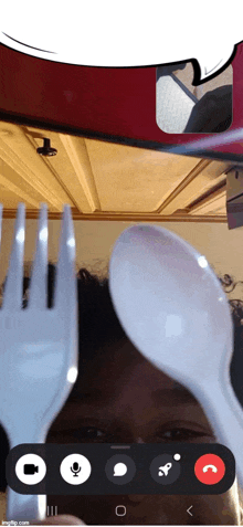 a person is holding a plastic fork and spoon over their head