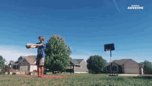 a boy in a blue shirt is holding a basketball in front of a basketball hoop that says awesome on the bottom