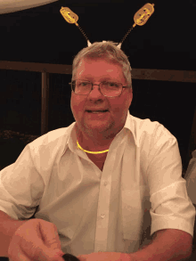 a man wearing a glow in the dark necklace and a bee headpiece