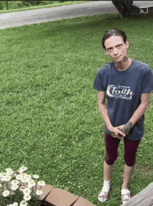 a woman wearing a t-shirt that says faith stand