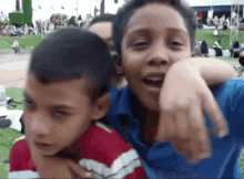 two young boys are posing for a picture and one is pointing