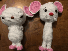 two crocheted white mice with pink ears and legs