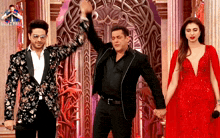 a woman in a red dress stands next to a man in a black jacket