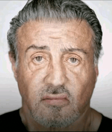 a close up of a man 's face with a beard and gray hair