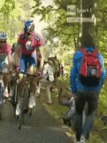 a group of people are riding bicycles down a road with a sign that says " park sport " in the background