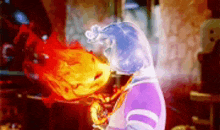 a person in a purple shirt is holding a fireball .