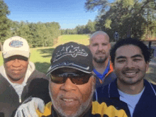 a group of men are posing for a picture on a golf course ..