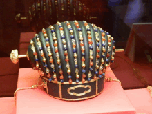 a black and gold crown with beads and a circle on it