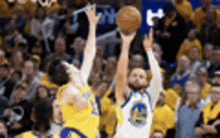 a basketball player is shooting a basketball while another player watches .