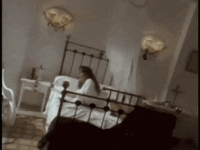 a woman laying on a bed with a cross on the wall