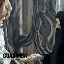 a poster for the guarimba international film festival shows a man and woman shaking hands