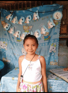 a little girl stands in front of a birthday banner that says happy birthday