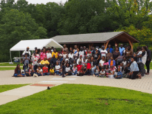 a large group of people are posing for a picture in front of a covered area