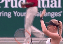 a woman is holding a tennis racquet in front of a green sign that says " ring your challenges "