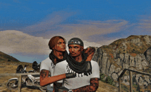 a man and a woman are standing next to each other in front of a mountain