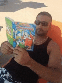 a man wearing sunglasses is reading a comic book called mickey mouse