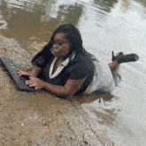 a woman is laying in the water with a keyboard