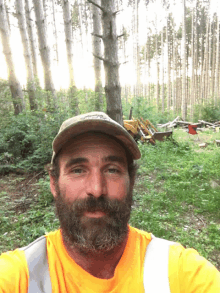 a man with a beard wearing a yellow shirt and safety vest