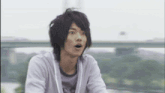 a young man with a surprised look on his face is wearing a white sweatshirt