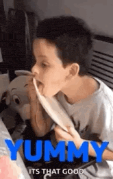 a young boy is eating spaghetti from a plate with his tongue sticking out .