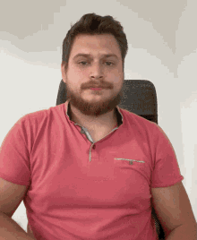 a man with a beard wearing a pink polo shirt