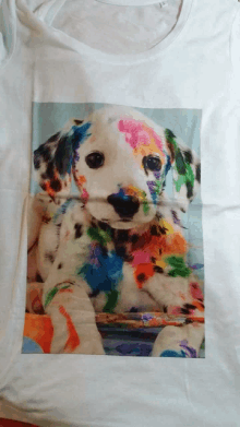 a dalmatian puppy is covered in paint on a shirt