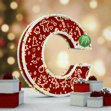 the letter c is decorated with christmas decorations and is surrounded by gifts