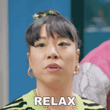 a woman wearing a zebra print sweater and earrings has the word relax on her face