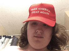 a man wearing a red make america great again hat