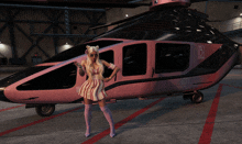 a woman is standing in front of a pink helicopter with the letter b on it