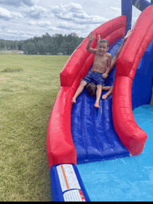 two young boys are playing on a large inflatable water slide