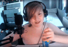 a young man wearing headphones is holding a can of sprite