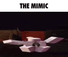 a skeleton is coming out of a box with the words `` the mimic '' written on it .