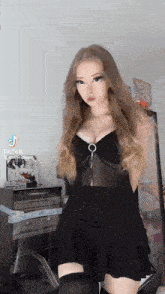 a woman in a black dress and thigh high socks is standing in a room .